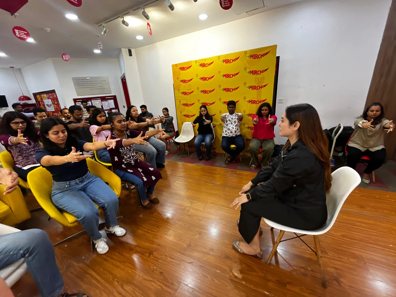 Vibha Jain guiding a group session, with participants seated together taking part in a shared exercise