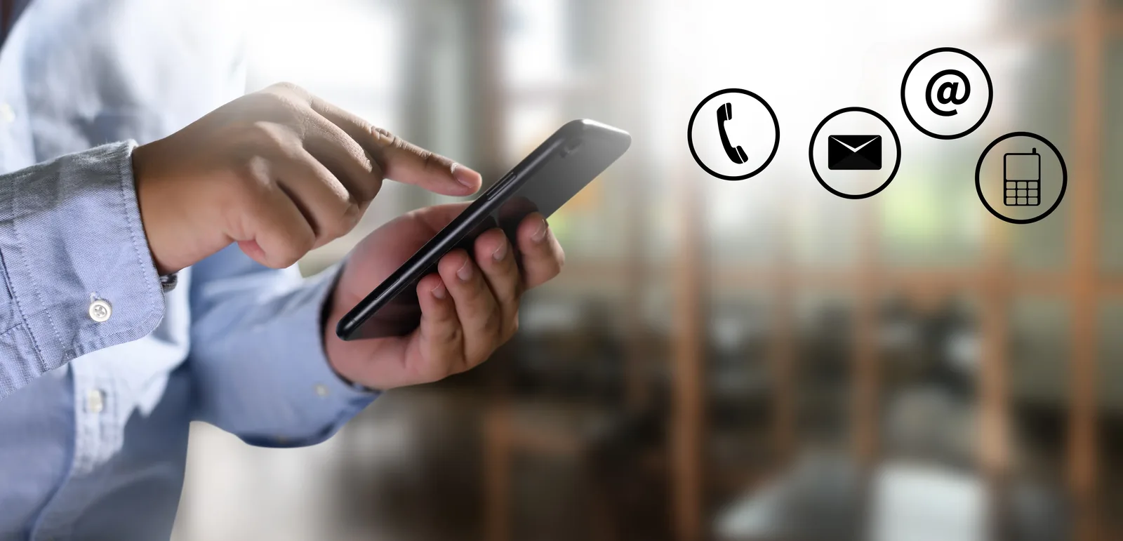 A person using a mobile phone with contact and enquiry icons beside them
